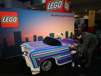 People are looking at a car made of LEGO bricks at the Canadian International Auto Show in Toronto, Canada, on February 19, 2024. (