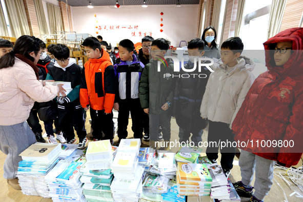 Students are receiving new textbooks at Yuanqian Primary School in Lianyungang, China, on February 20, 2024. 