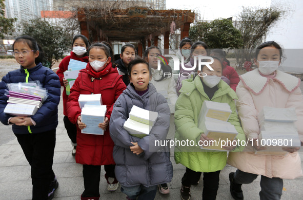 Students are receiving new textbooks at Yuanqian Primary School in Lianyungang, China, on February 20, 2024. 