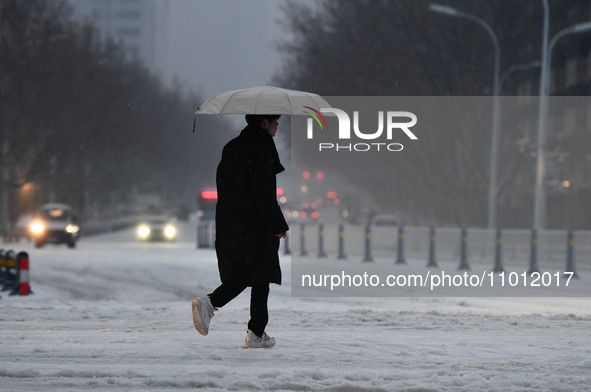 Citizens are walking in the snow on a street in Fuyang, China, on February 21, 2024. 