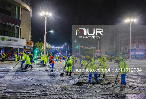 Sanitation workers are removing snow from a main road in Suqian, Jiangsu Province, China, on February 21, 2024. 