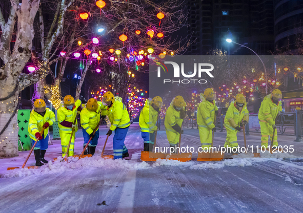 Sanitation workers are removing snow from a main road in Suqian, Jiangsu Province, China, on February 21, 2024. 