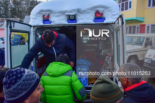 People are carrying the dead body of a skier who was killed after an avalanche struck the Ski resort in Gulmarg, Baramulla District, Indian...