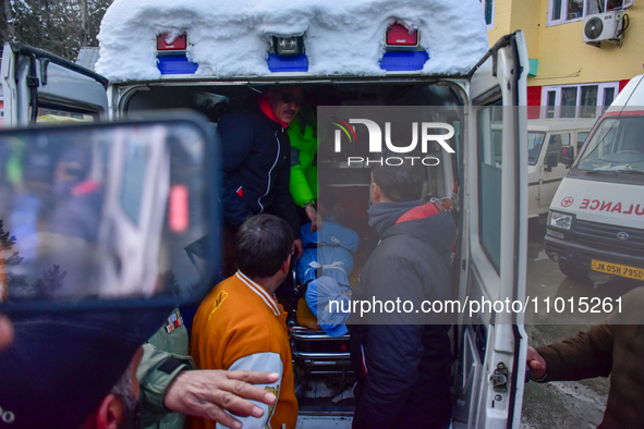 People are carrying the dead body of a skier who was killed after an avalanche struck the Ski resort in Gulmarg, Baramulla District, Indian...