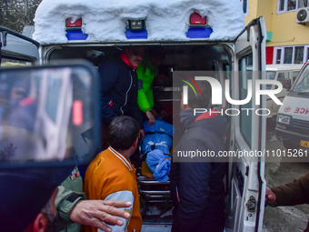 People are carrying the dead body of a skier who was killed after an avalanche struck the Ski resort in Gulmarg, Baramulla District, Indian...