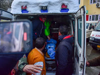 People are carrying the dead body of a skier who was killed after an avalanche struck the Ski resort in Gulmarg, Baramulla District, Indian...