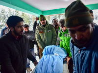 People are carrying the dead body of a skier who was killed after an avalanche struck the Ski resort in Gulmarg, Baramulla District, Indian...