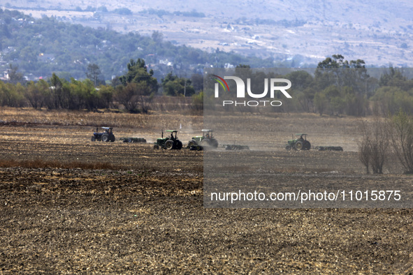 A farmer is plowing the land on a tractor in the affected area of the Zumpango lagoon, which is experiencing drought due to the lack of rain...