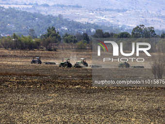 A farmer is plowing the land on a tractor in the affected area of the Zumpango lagoon, which is experiencing drought due to the lack of rain...