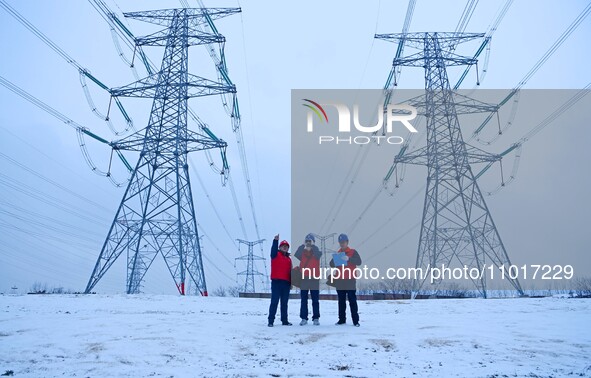 Electric workers are braving cold temperatures in the snow to inspect the 500-kilovolt cross-city transmission line and the Beijing-Shanghai...