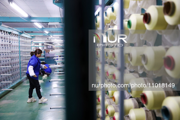 A female worker is preparing to twist silk at a production workshop of a silk company in Chongqing, China, on February 23, 2024. 