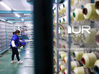 A female worker is preparing to twist silk at a production workshop of a silk company in Chongqing, China, on February 23, 2024. (