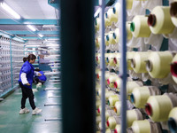 A female worker is preparing to twist silk at a production workshop of a silk company in Chongqing, China, on February 23, 2024. (