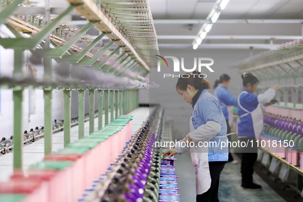 A female worker is merging silk at a production workshop of a silk company in Chongqing, China, on February 23, 2024. 