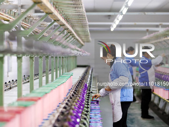 A female worker is merging silk at a production workshop of a silk company in Chongqing, China, on February 23, 2024. (