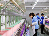 A female worker is merging silk at a production workshop of a silk company in Chongqing, China, on February 23, 2024. (