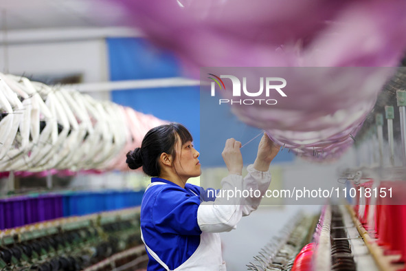 A female worker is merging silk at a production workshop of a silk company in Chongqing, China, on February 23, 2024. 