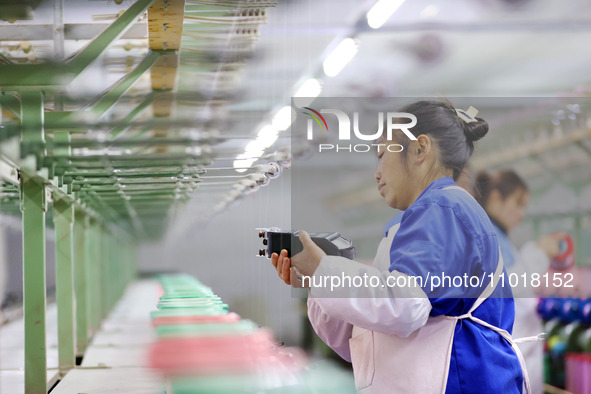 A female worker is merging silk at a production workshop of a silk company in Chongqing, China, on February 23, 2024. 