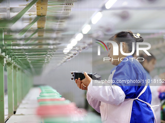 A female worker is merging silk at a production workshop of a silk company in Chongqing, China, on February 23, 2024. (