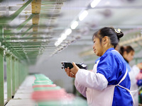 A female worker is merging silk at a production workshop of a silk company in Chongqing, China, on February 23, 2024. (