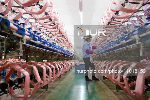 A female worker is merging silk at a production workshop of a silk company in Chongqing, China, on February 23, 2024. 