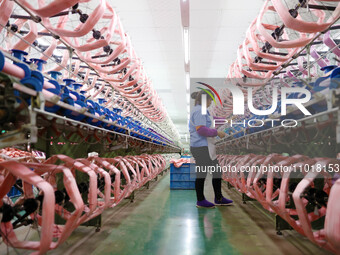 A female worker is merging silk at a production workshop of a silk company in Chongqing, China, on February 23, 2024. (