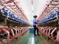 A female worker is merging silk at a production workshop of a silk company in Chongqing, China, on February 23, 2024. (