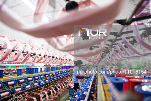 A female worker is merging silk at a production workshop of a silk company in Chongqing, China, on February 23, 2024. 