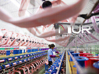 A female worker is merging silk at a production workshop of a silk company in Chongqing, China, on February 23, 2024. (