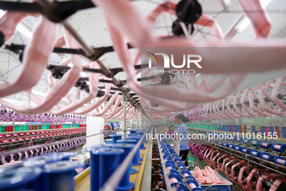 A female worker is merging silk at a production workshop of a silk company in Chongqing, China, on February 23, 2024. 