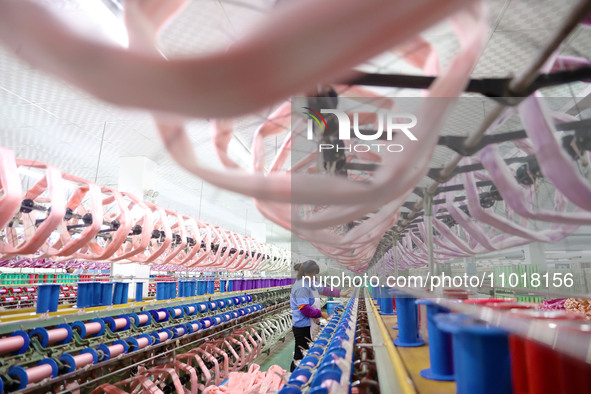 A female worker is merging silk at a production workshop of a silk company in Chongqing, China, on February 23, 2024. 