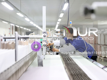 A female worker is weaving silk at a workshop of a silk company in Chongqing, China, on February 23, 2024. (