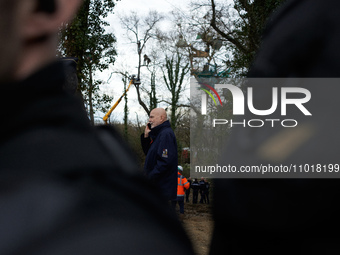 Michel Forst is speaking on the phone while policemen are arresting an 'Ecureuil' in a tree in a very dangerous situation in Saix, France, o...