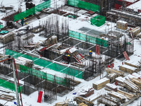 Workers are working at a building construction site as snow is falling in Nanjing, China, on February 24, 2024. (