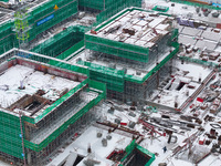 Workers are working at a building construction site as snow is falling in Nanjing, China, on February 24, 2024. (