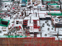 Workers are working at a building construction site as snow is falling in Nanjing, China, on February 24, 2024. (