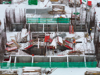 Workers are working at a building construction site as snow is falling in Nanjing, China, on February 24, 2024. (