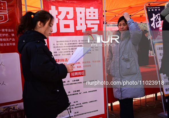 Job seekers are learning about job openings at a booth of an employment company at a spring job fair for SMEs in Liaocheng, China, on Februa...