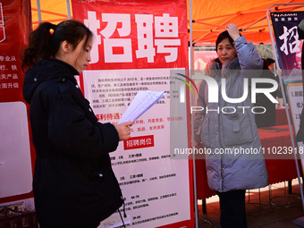 Job seekers are learning about job openings at a booth of an employment company at a spring job fair for SMEs in Liaocheng, China, on Februa...