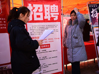 Job seekers are learning about job openings at a booth of an employment company at a spring job fair for SMEs in Liaocheng, China, on Februa...