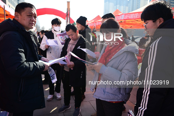 Job seekers are learning about job openings at a booth of an employment company at a spring job fair for SMEs in Liaocheng, China, on Februa...