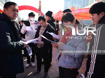 Job seekers are learning about job openings at a booth of an employment company at a spring job fair for SMEs in Liaocheng, China, on Februa...