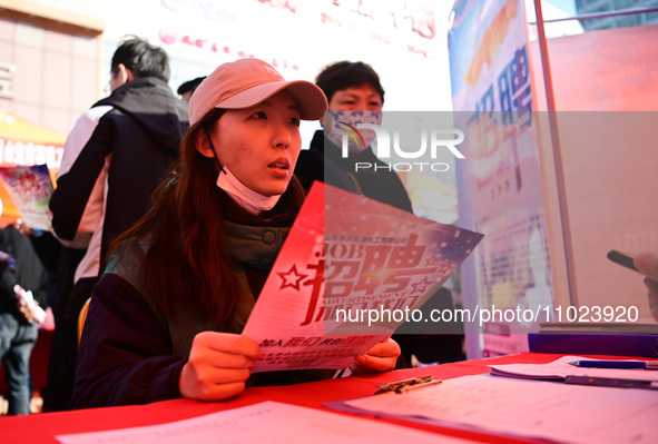 Job seekers are asking for employment information in front of a booth of an employment company at a spring job fair for SMEs in Liaocheng, C...