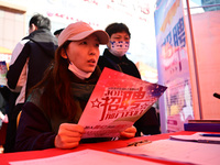 Job seekers are asking for employment information in front of a booth of an employment company at a spring job fair for SMEs in Liaocheng, C...