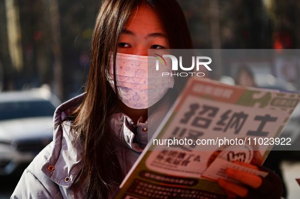 Job seekers are learning about job openings at a booth of an employment company at a spring job fair for SMEs in Liaocheng, China, on Februa...