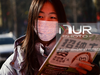 Job seekers are learning about job openings at a booth of an employment company at a spring job fair for SMEs in Liaocheng, China, on Februa...