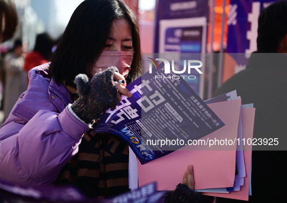 Job seekers are learning about job openings at a booth of an employment company at a spring job fair for SMEs in Liaocheng, China, on Februa...