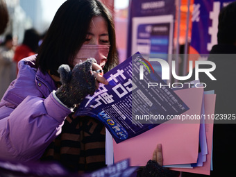 Job seekers are learning about job openings at a booth of an employment company at a spring job fair for SMEs in Liaocheng, China, on Februa...