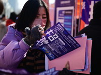 Job seekers are learning about job openings at a booth of an employment company at a spring job fair for SMEs in Liaocheng, China, on Februa...