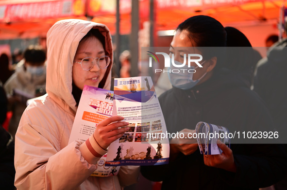 Job seekers are learning about job openings at a booth of an employment company at a spring job fair for SMEs in Liaocheng, China, on Februa...